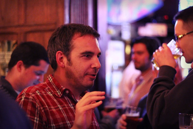 man in the middle of two people eating and drinking at a bar