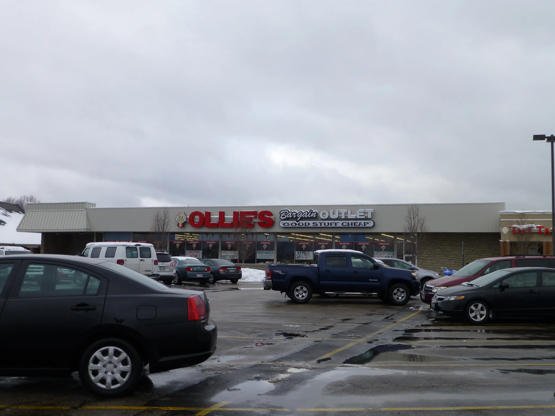 a parking lot full of cars in front of a convenience store