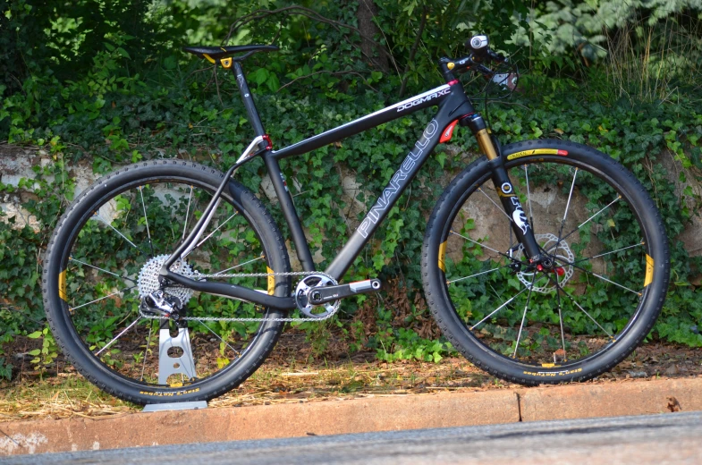 a bicycle with all black and yellow tires parked on some side walk