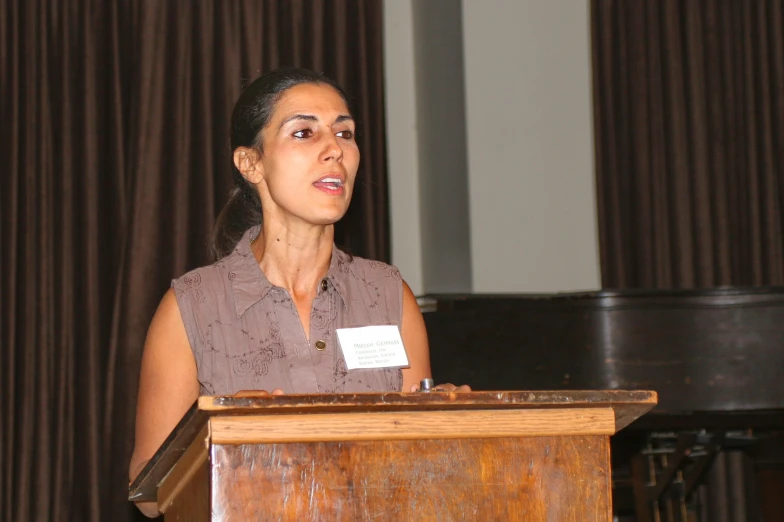 a woman in a dress stands at a podium