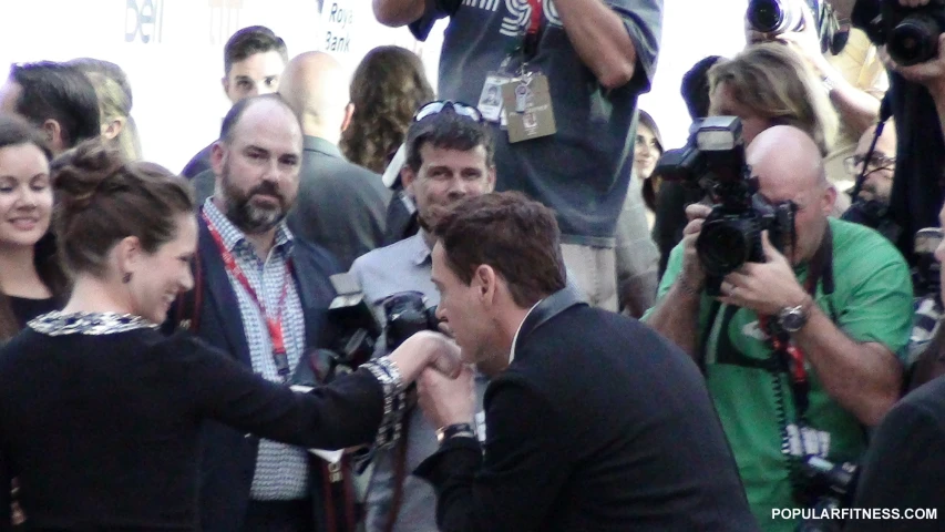 a man being interviewed by some pographers on a street