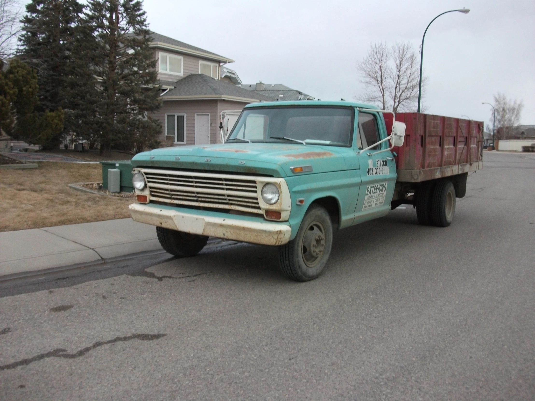 the truck is parked near the curb with the empty sidewalk