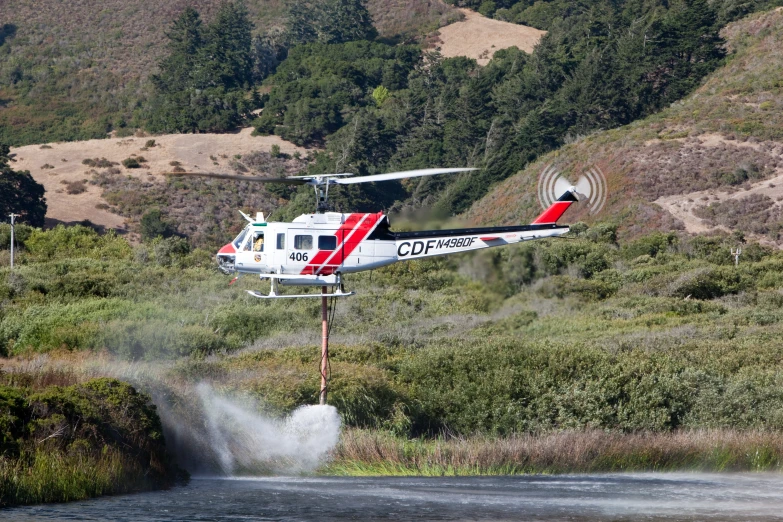 an air plane spraying water on top of a hillside