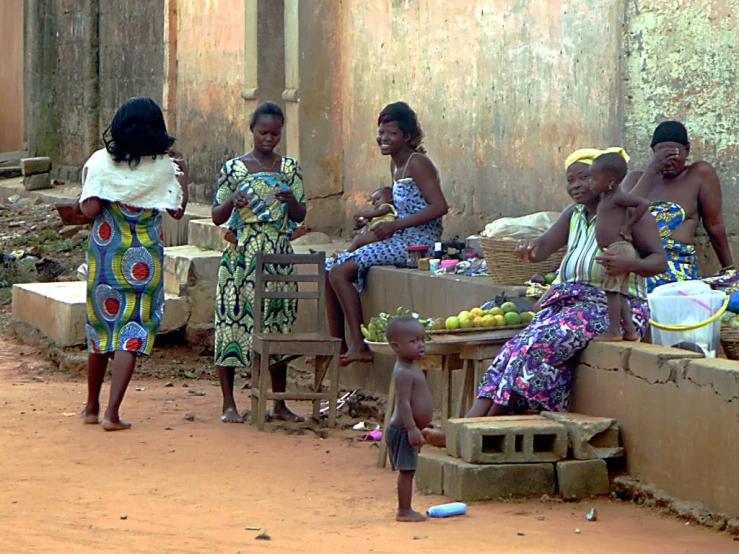 a group of women sitting around outside of a store