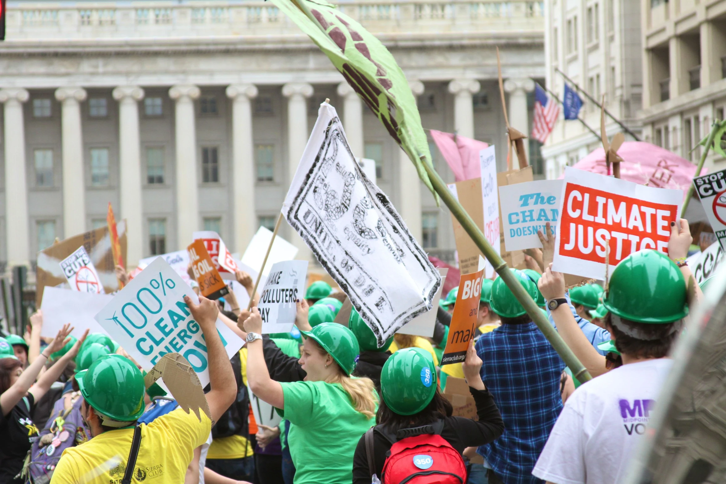 a crowd of people with protest signs, hats and backpacks