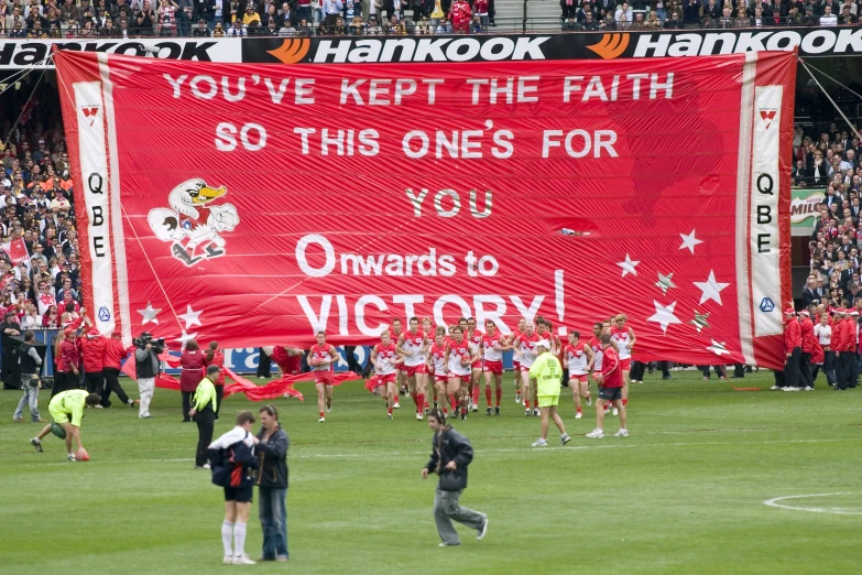 some soccer players with a large banner in a stadium