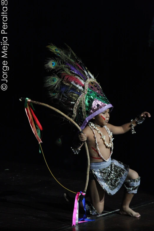 a young child in a hula skirt is holding a whip rope
