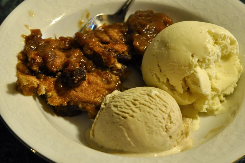 ice cream, meat, and fruit in a bowl on a table