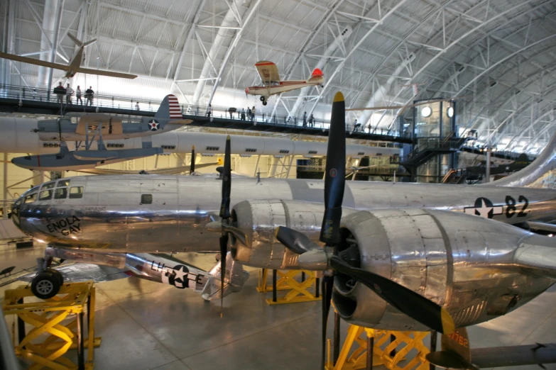 a silver plane sitting inside of a hangar