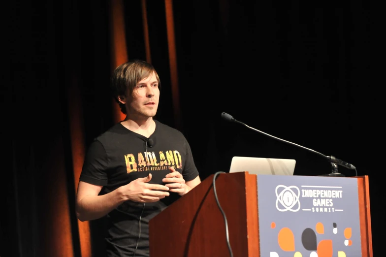 a man standing in front of a microphone at a podium