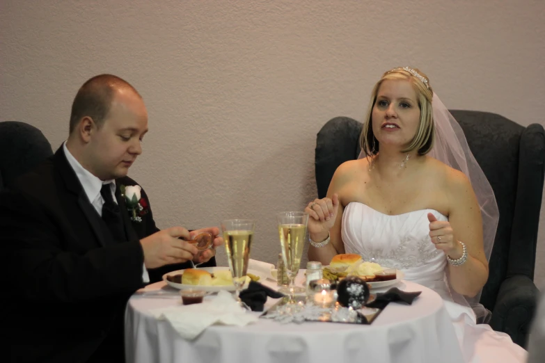 man and woman in a black suit eat at a dinner table