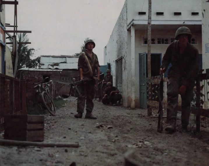 a couple of people standing in the dirt with a bike