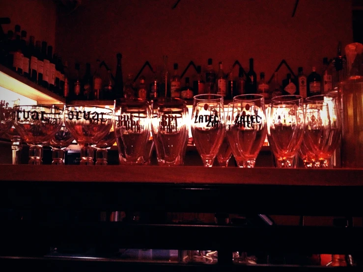 a long wall of wine glasses in front of the bar