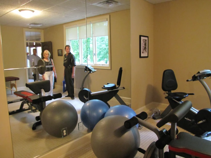 the couple are in their home gym room looking into the mirror