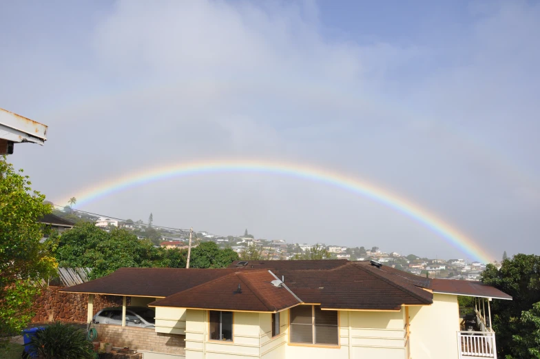 a rainbow over houses on a clear day