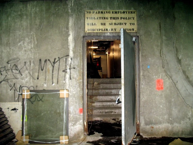 graffiti painted on a concrete wall and a doorway leading to another