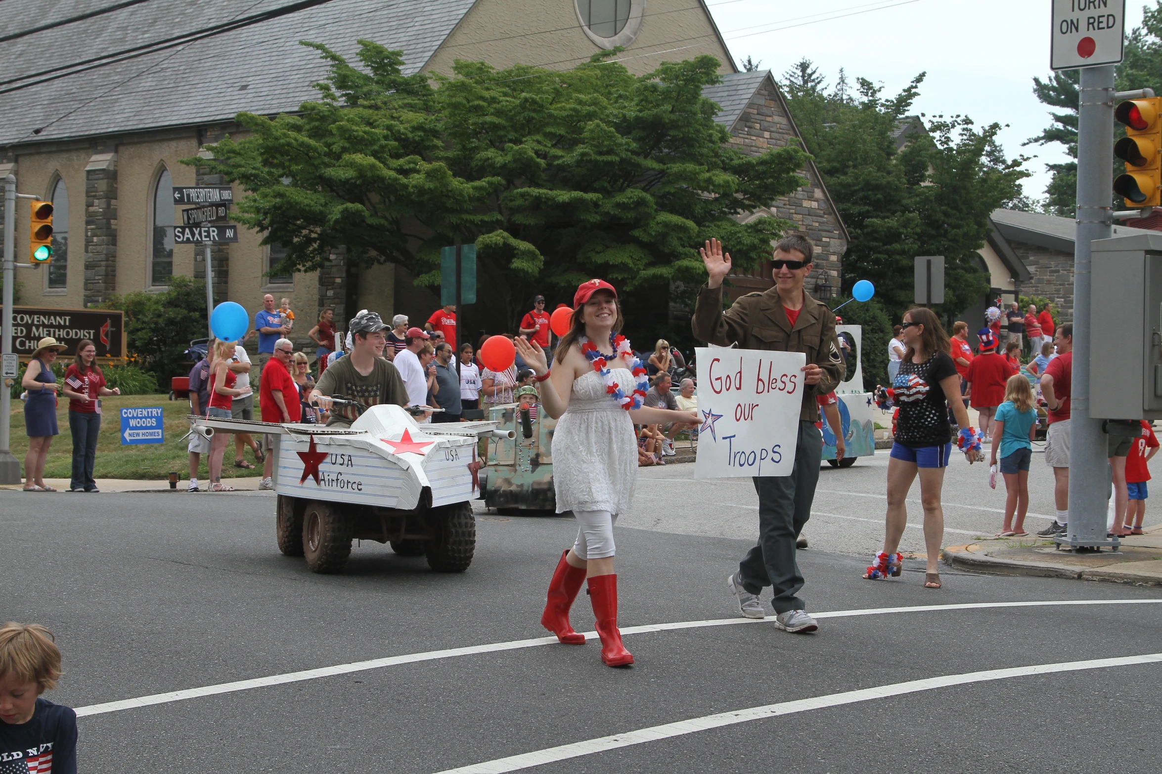 people in costumes are at an intersection, as other people hold signs