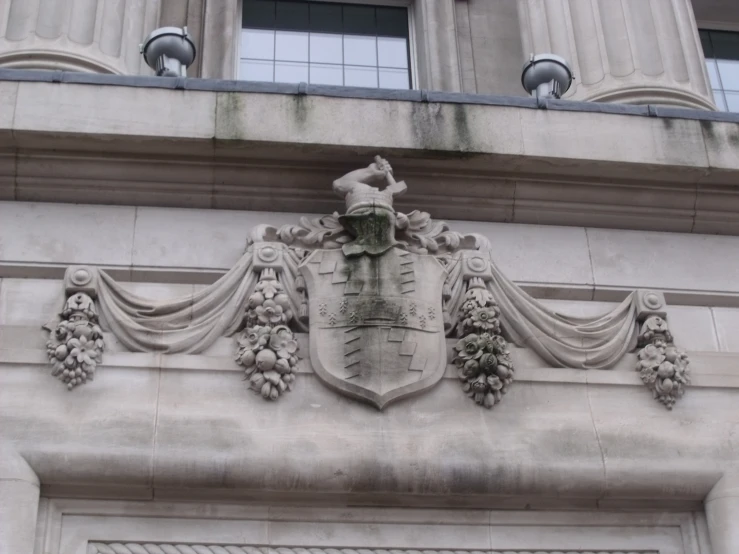 a coat of arms and two gs on top of the building