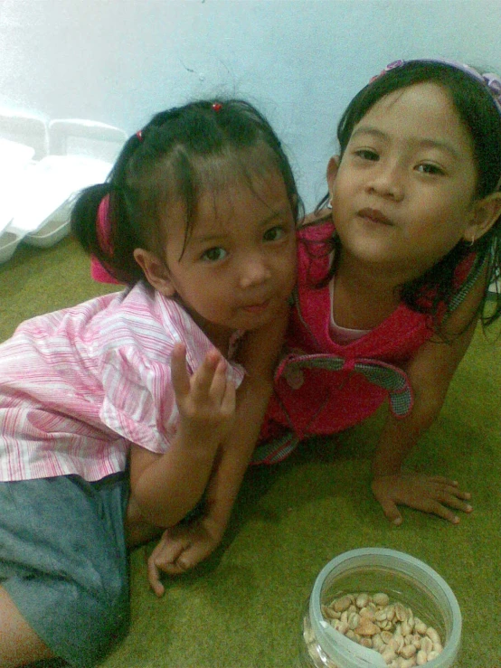 a group of girls on the ground eating