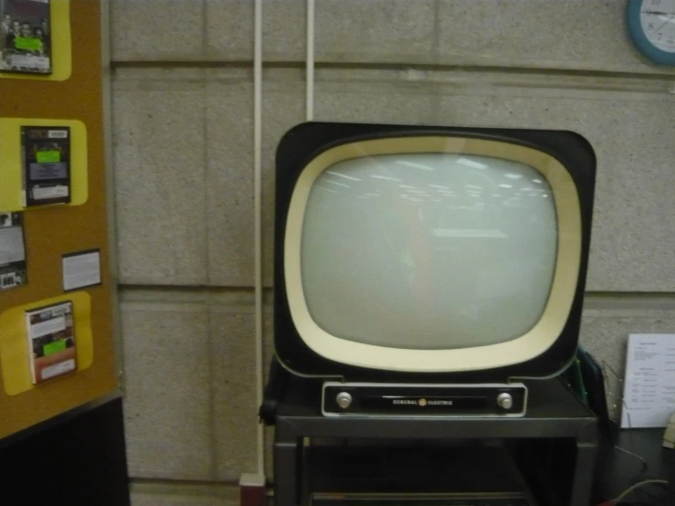 an old television set is in a room with notes and pictures around it