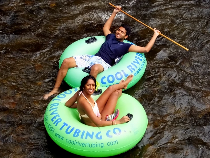 two people are riding on tubes in the water