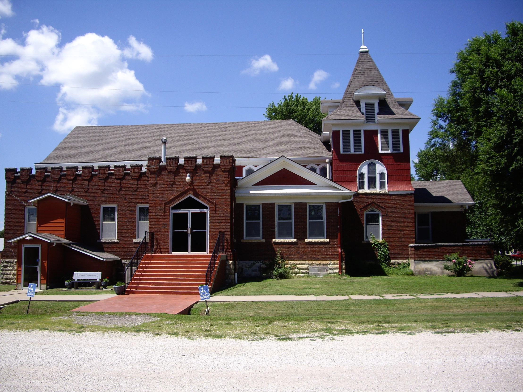 an old red brick house with the grass all around