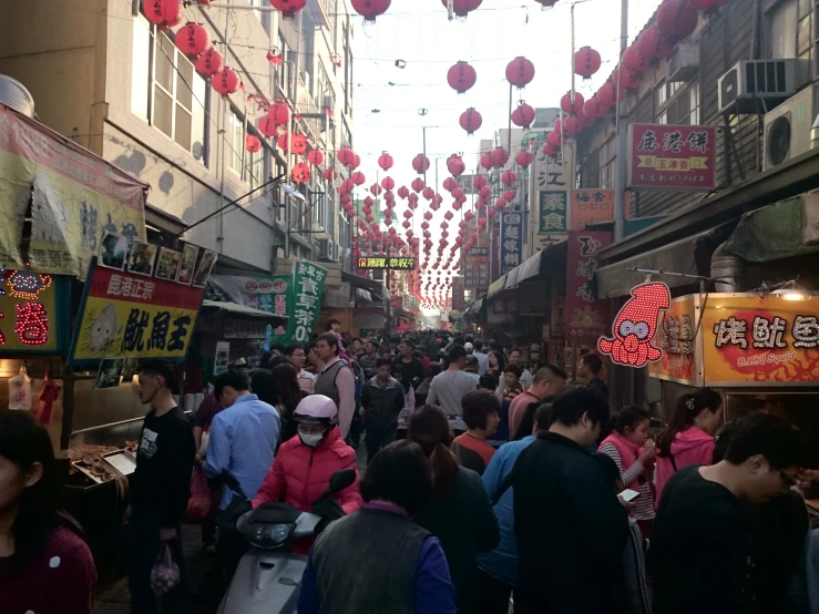 many people are standing in a narrow market