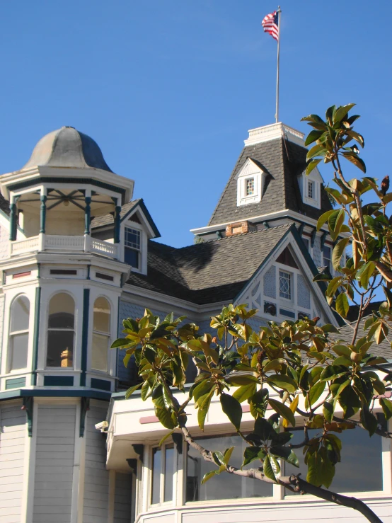 a large white and gray home with a flag at the top