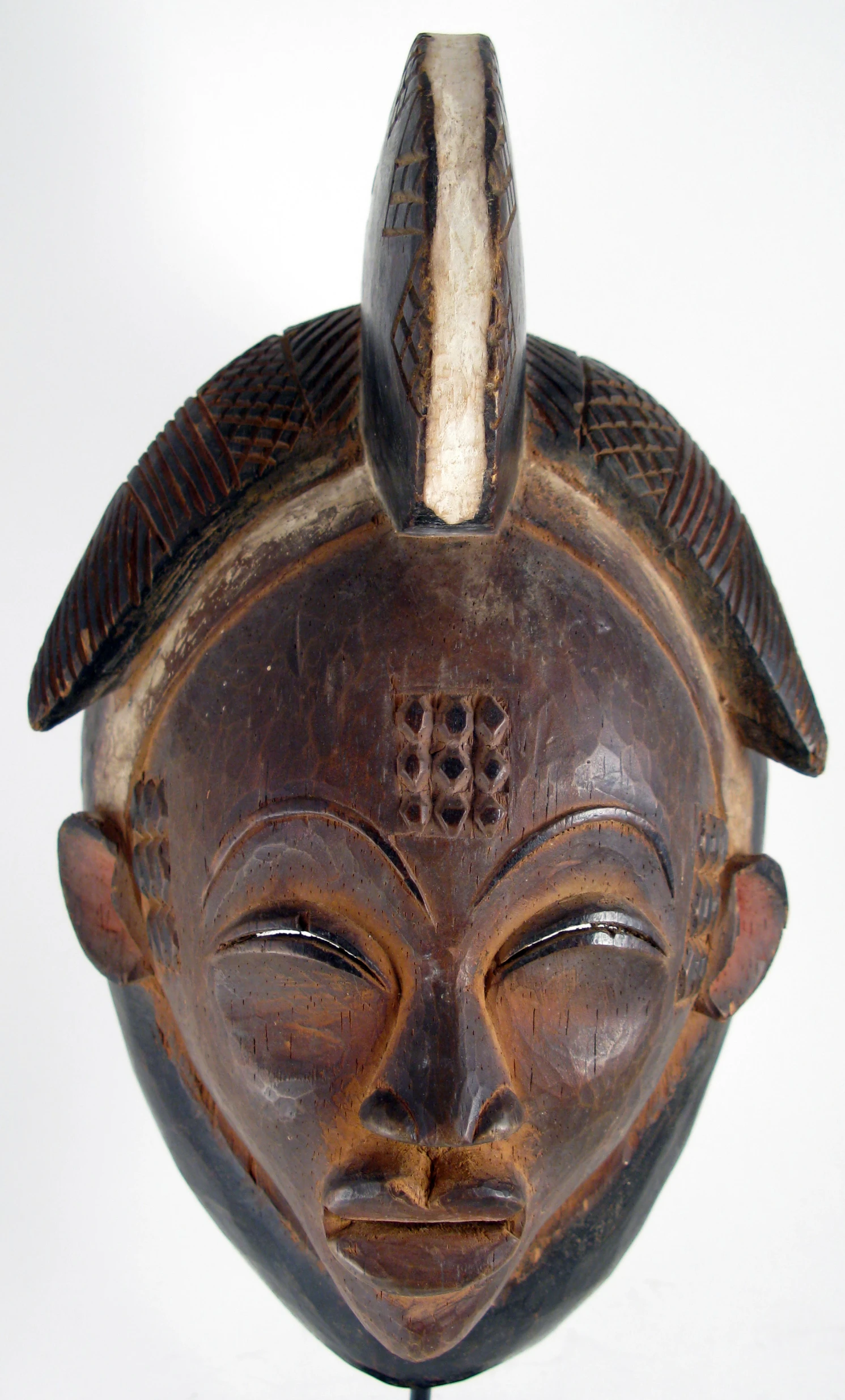 this wooden mask is adorned with intricate designs and birds