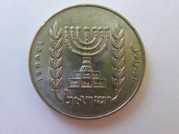 a gold medal with a lit menorah and stars on top