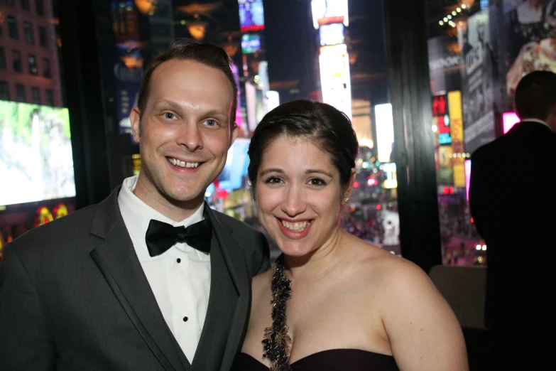 a man and woman standing next to each other at a party