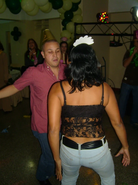 a woman and man are dancing together at a party