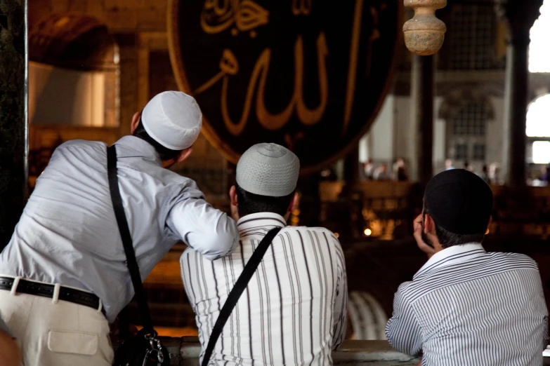 two muslim men looking at a store sign