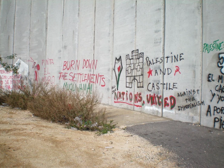 a wall with some grafitti and a fire hydrant on the ground