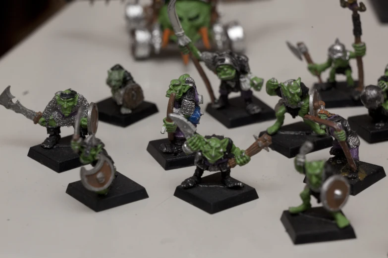 an assortment of green miniatures with warhammers