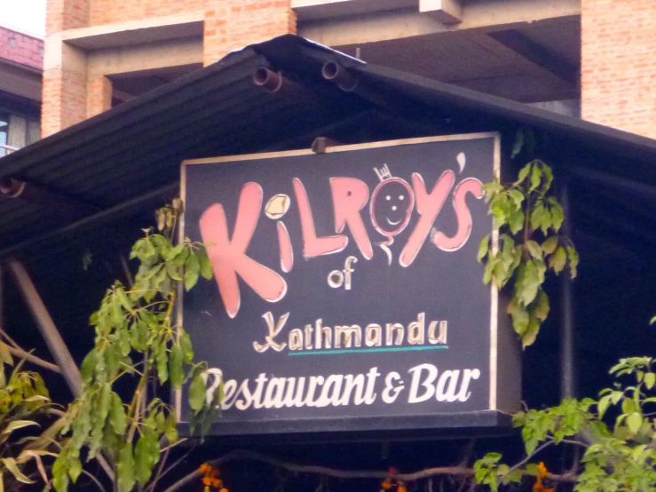 a sign for kirs of kahmaandau restaurant and bar hanging from a building