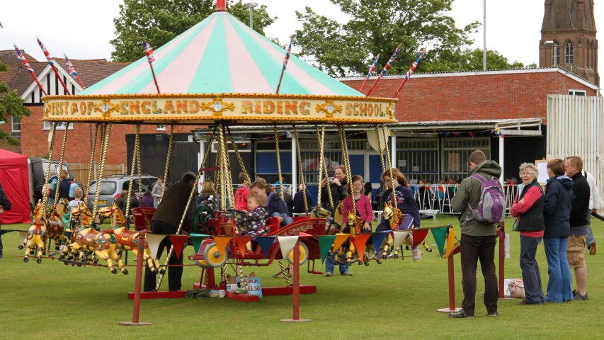 people are gathered around a brightly colored merry go round