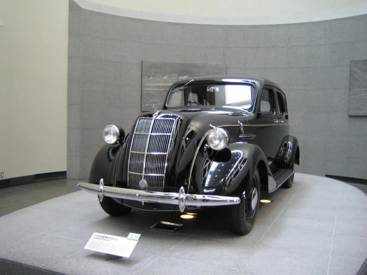 an antique black car on display in a museum