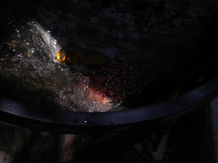 a close up of a metal sink with water splashing off it