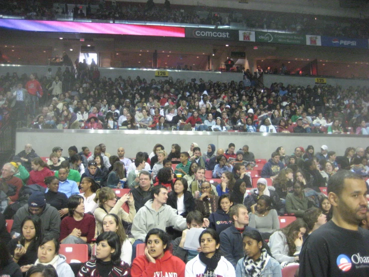 a crowd of people sitting in an auditorium next to one another
