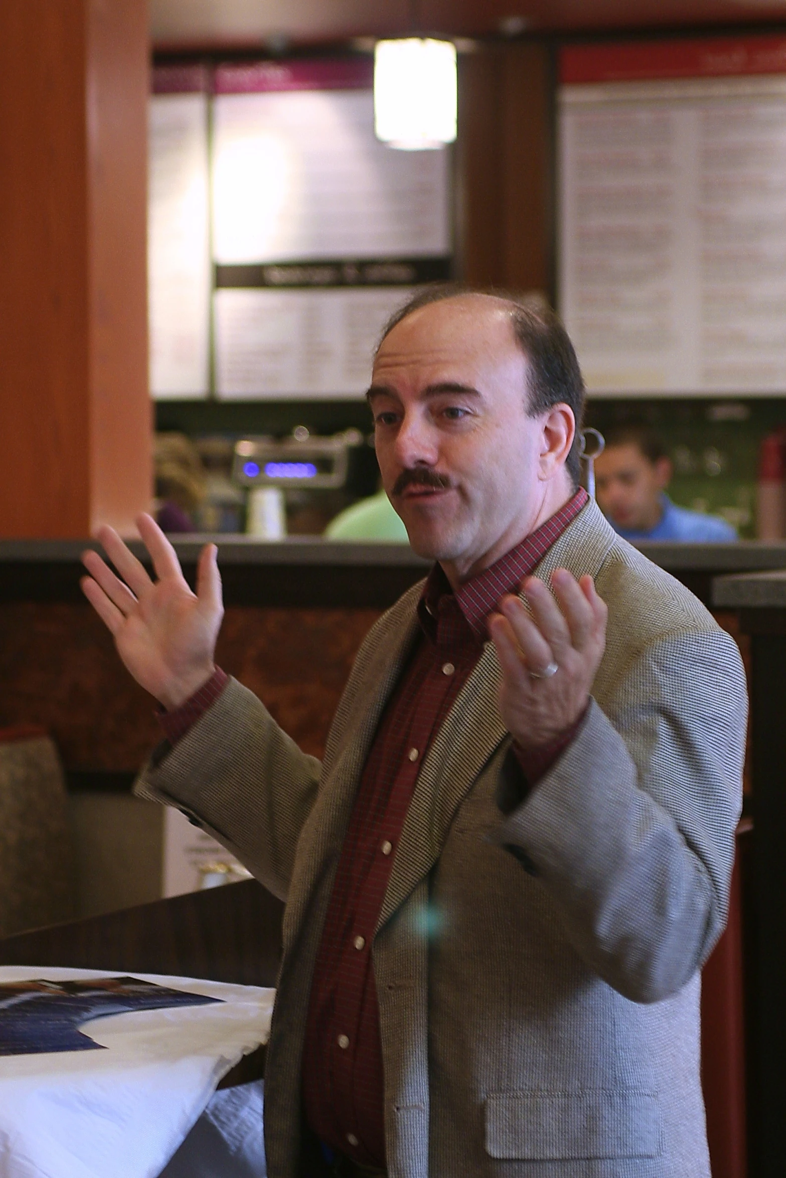 man in business suit holding his hands up and gesturing