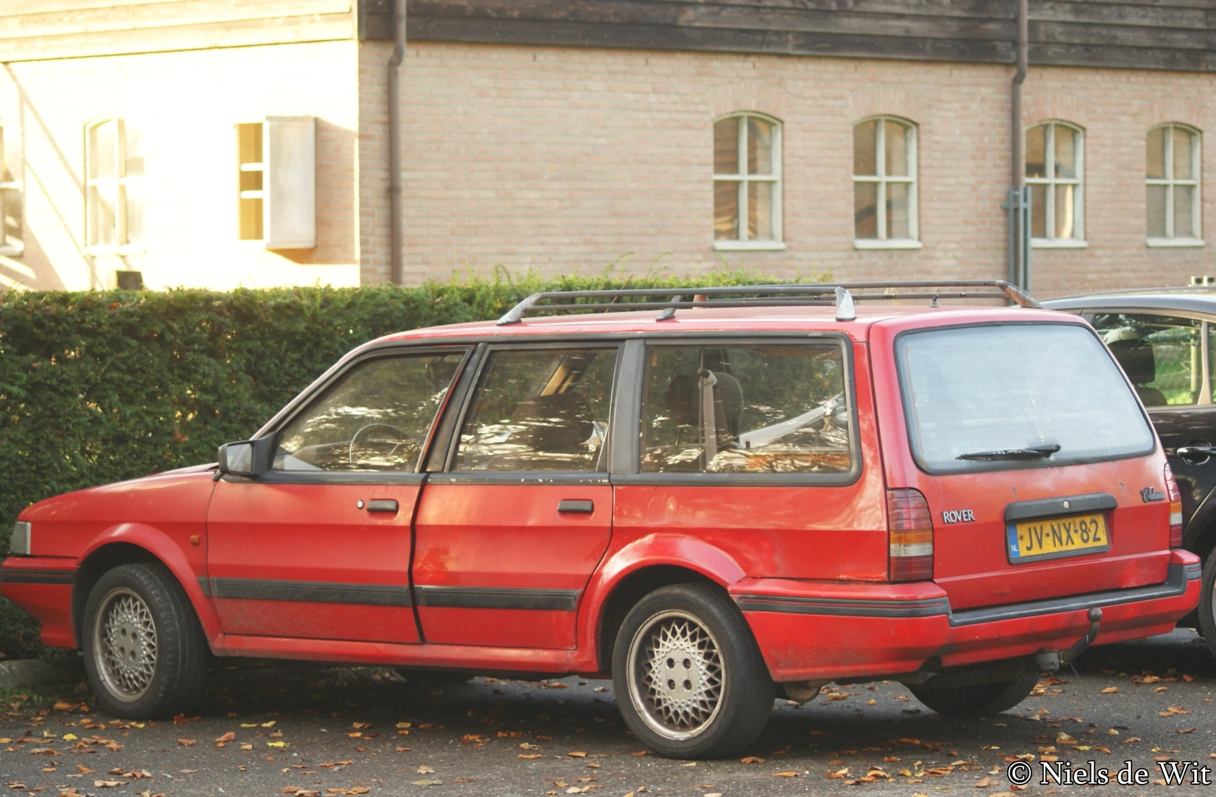 two red cars parked outside of a brick building