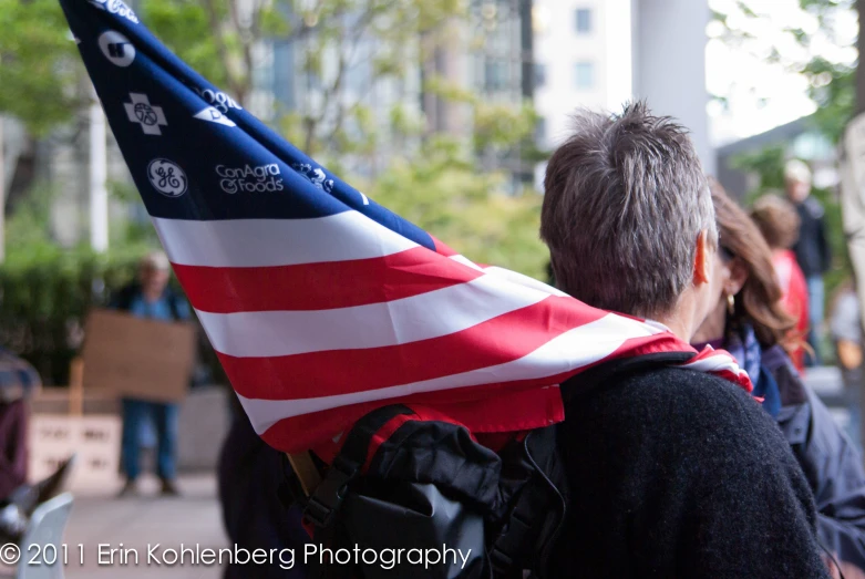 a  carrying an american flag on a street corner