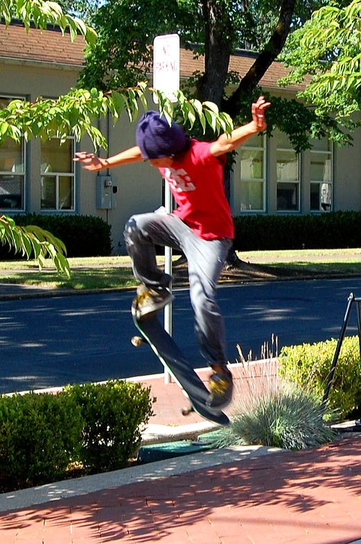 a boy riding a skateboard up on a sidewalk