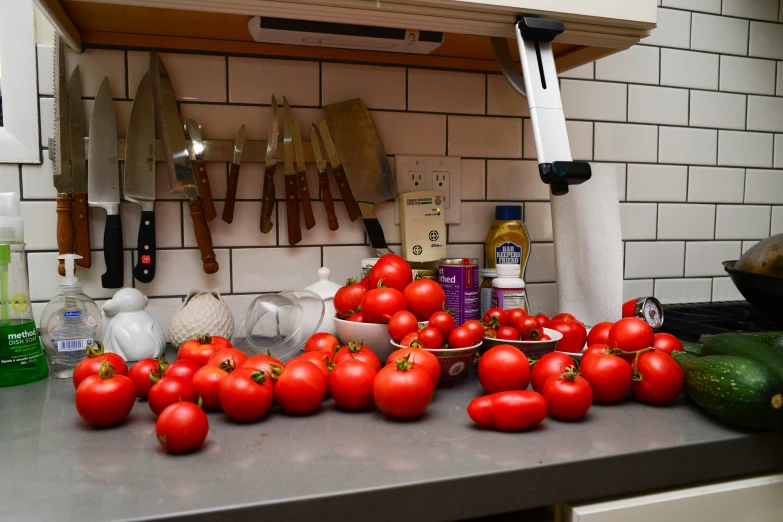 a kitchen counter with tomatoes and other fruits