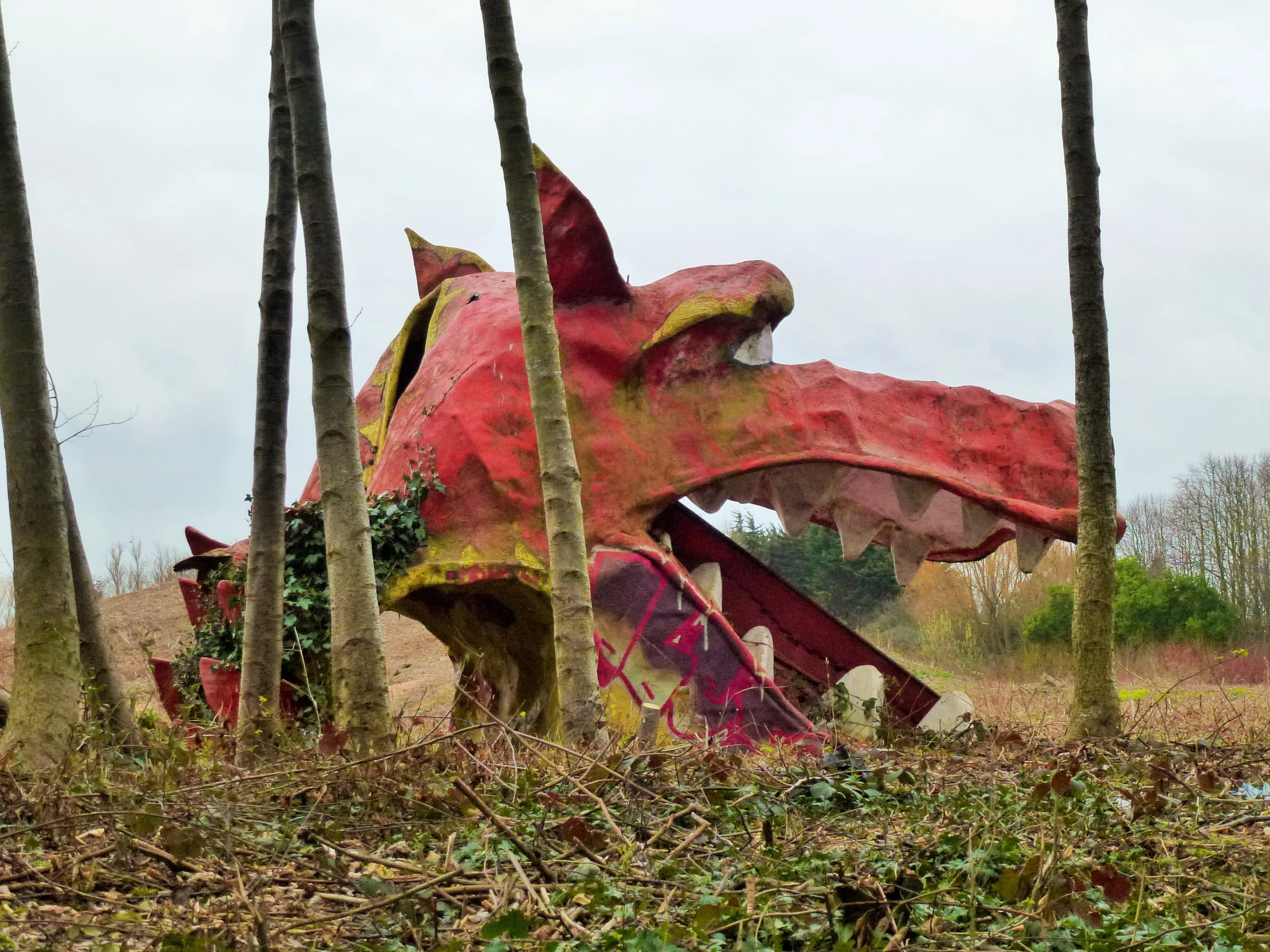 this large dinosaur is sitting in a field with several trees