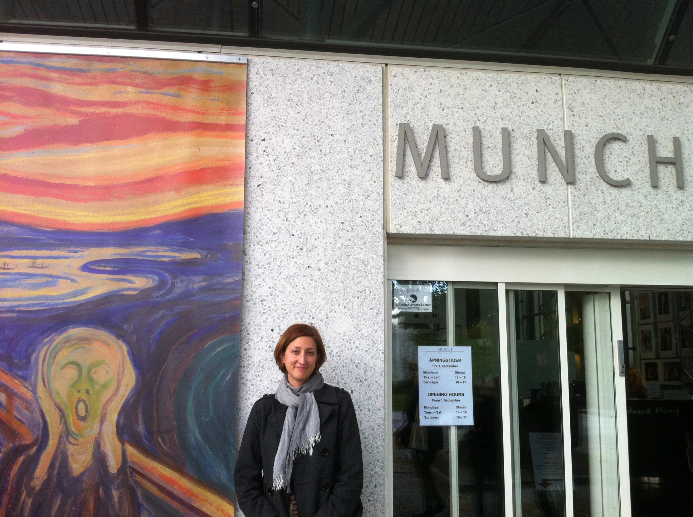 a woman standing in front of a painting on the wall