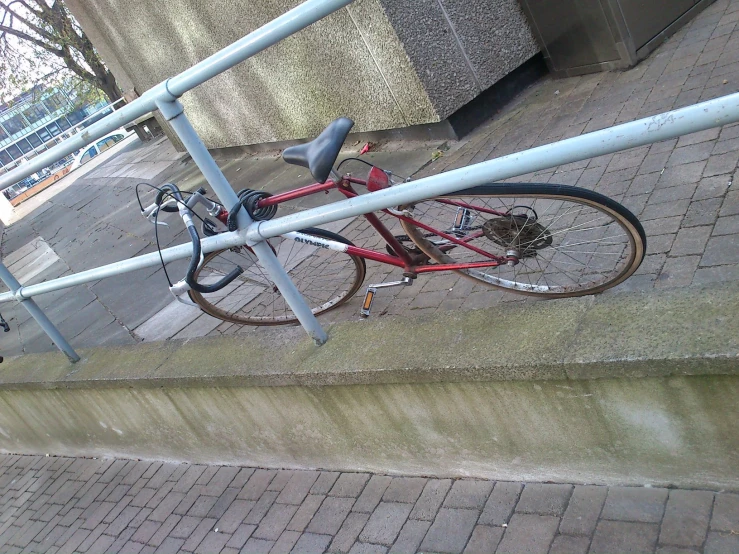 a red bike locked up next to a stairway