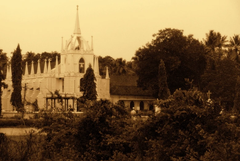 the back of a church near trees and bushes