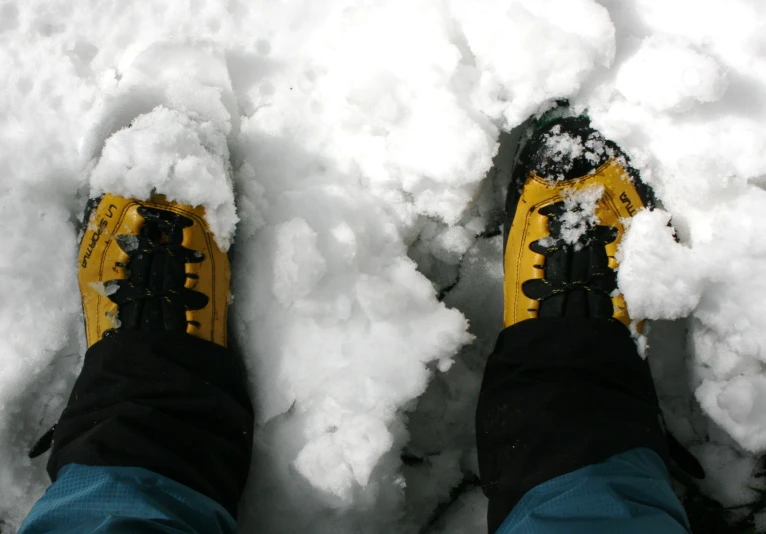 legs and feet with boots standing in a pile of snow